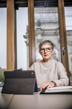 Britta Haßelmann arbeitet am Schreibtisch mit Tablet und verschiedenen Unterlagen.